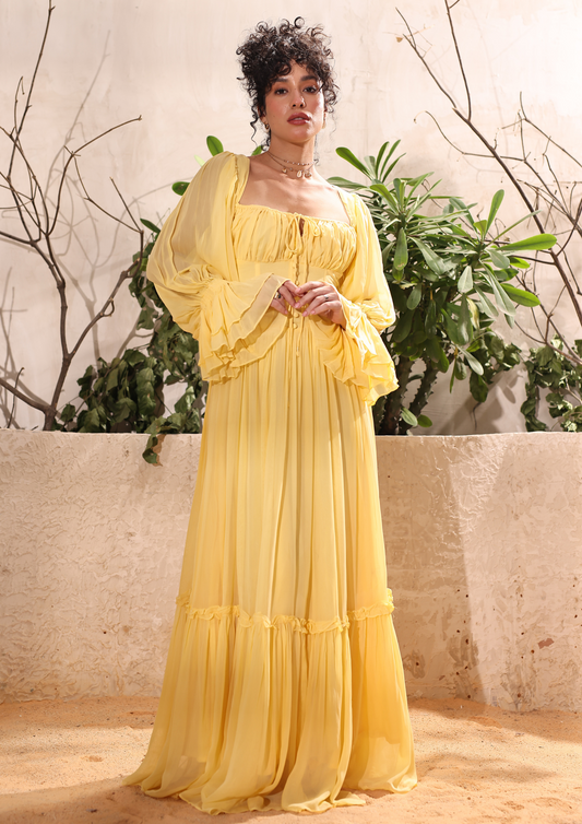 Seoraa Yellow Maxi Gown Dress with a corset bodice, crisscross back, tie bow, and ruched sleeves – perfect for haldi functions, weddings, birthdays, and romantic date nights.